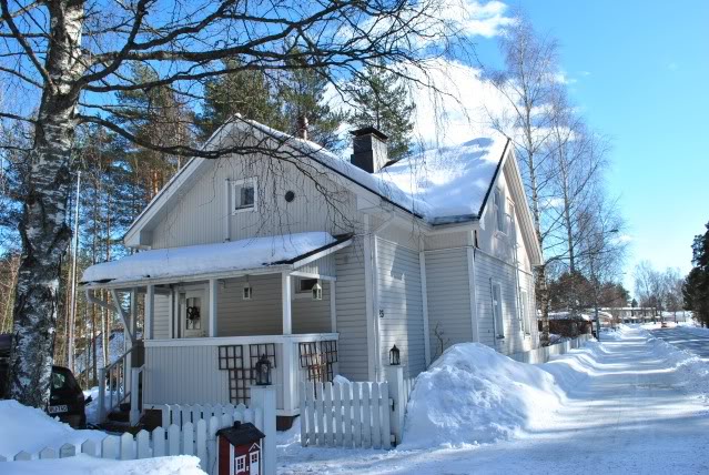 House surrounded by snow in clear sky, sunny weather in Finland.